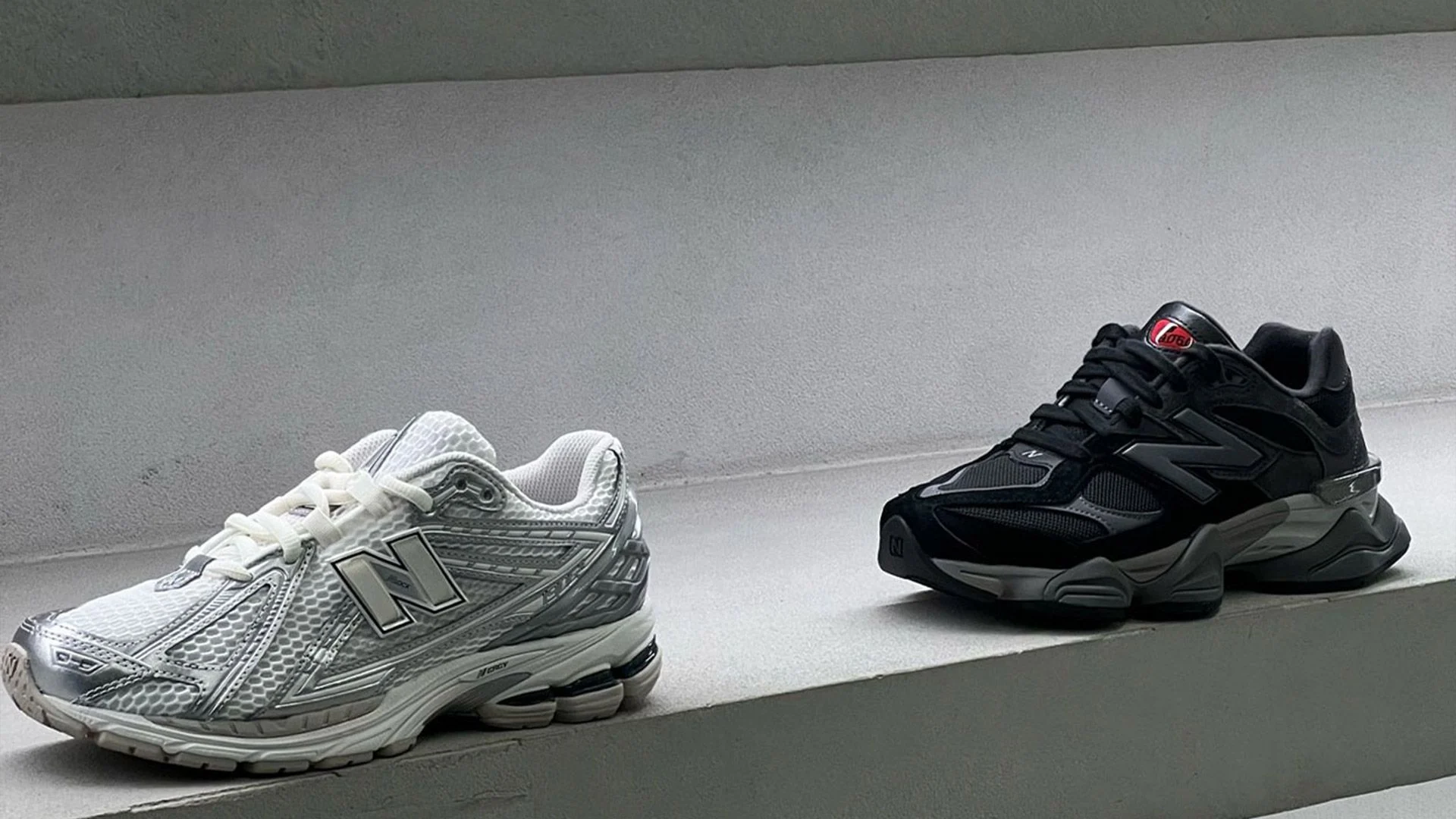 New Balance 1906 prata e 9060 preto sobre degraus de concreto